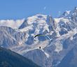 Sportif qui fait du parapente au milieu des montagnes enneigées de Savoie