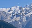 Sportif qui fait du parapente au milieu des montagnes enneigées de Savoie